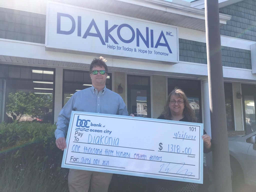 reid tingle holding big check in front of diakonia office